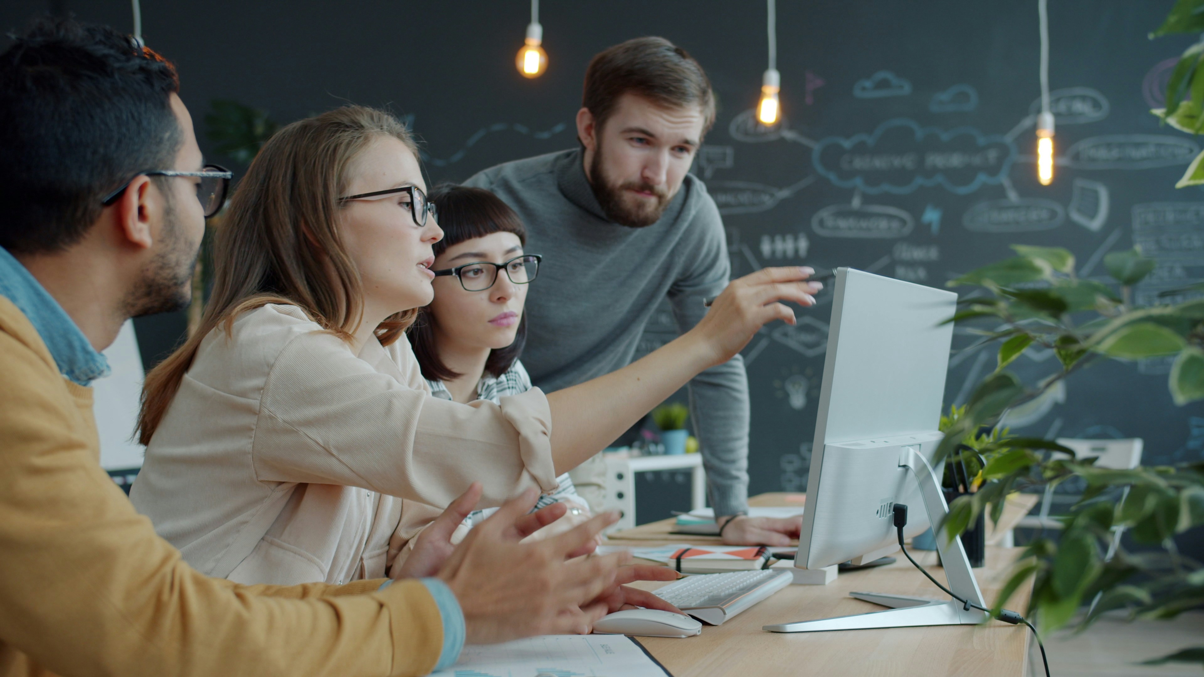 Team collaborating around a computer during an ERP implementation
